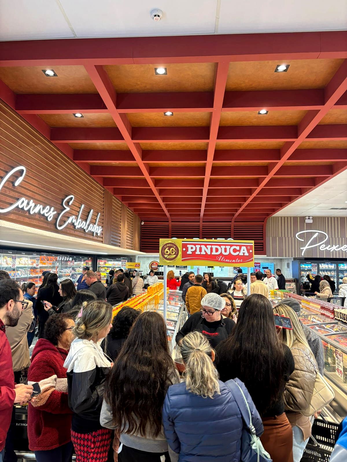 Público reunido em volta do balcão de degustação de uma marca em supermercado de Curitiba